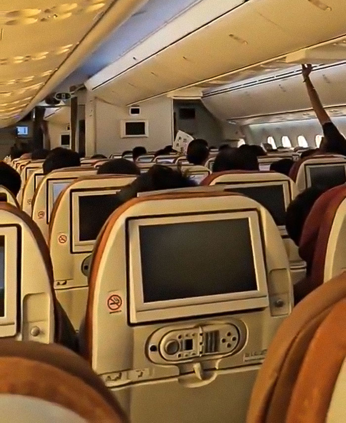 Passenger exposing tech failures on Air India Boeing jet with multiple seat screens visible inside the airplane cabin.