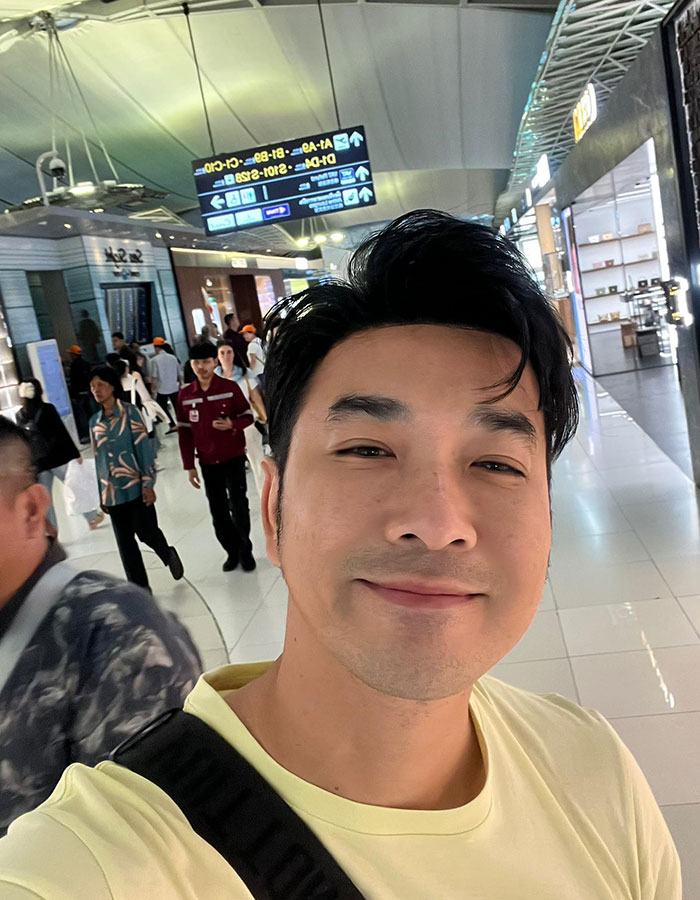 Thai actor smiling in airport, highlighting plane crash survival and eerie link to Air India&rsquo;s only survivor story