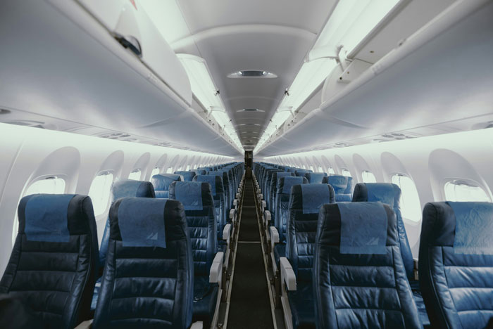 Empty airplane cabin interior with rows of seats, related to Thai actor who survived plane crash and Air India survivor link