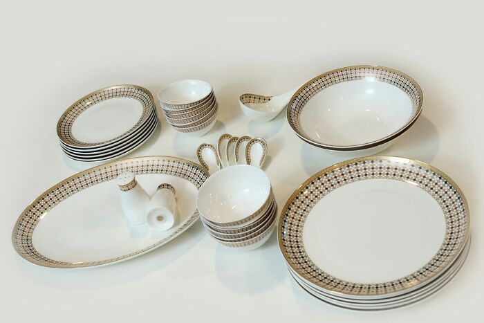 Set of elegant white and gold-trimmed dishware, illustrating industries impacted by millennials dining habits.