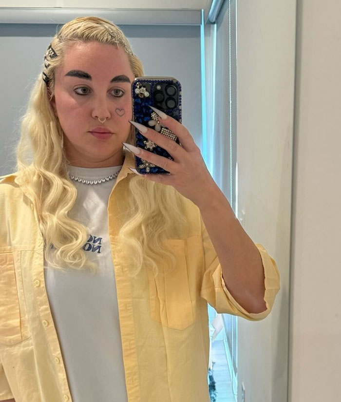 Amanda Bynes taking a mirror selfie with long blonde hair, highlighting her use of Ozempic and public reactions.