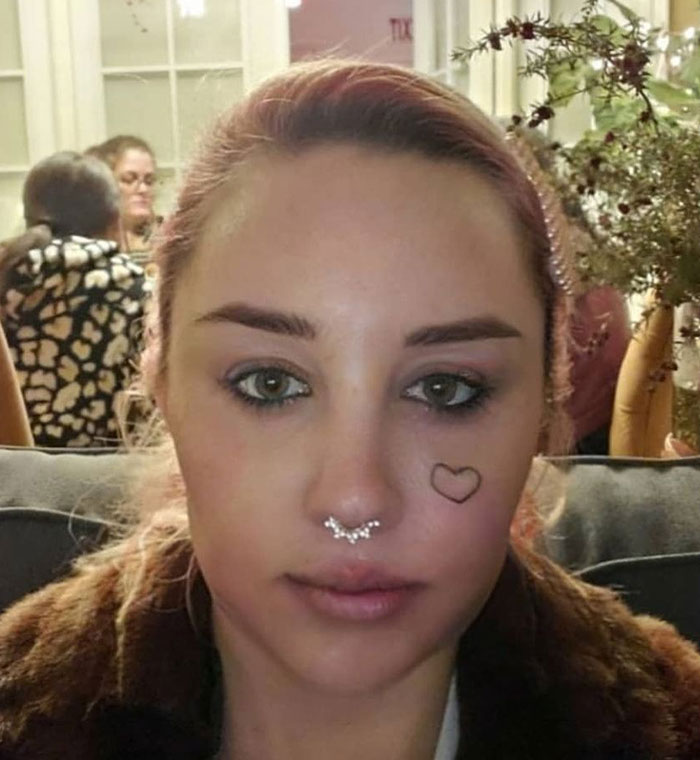 Amanda Bynes with septum piercing and heart tattoo on cheek after revealing she is using Ozempic sparking mixed reactions.