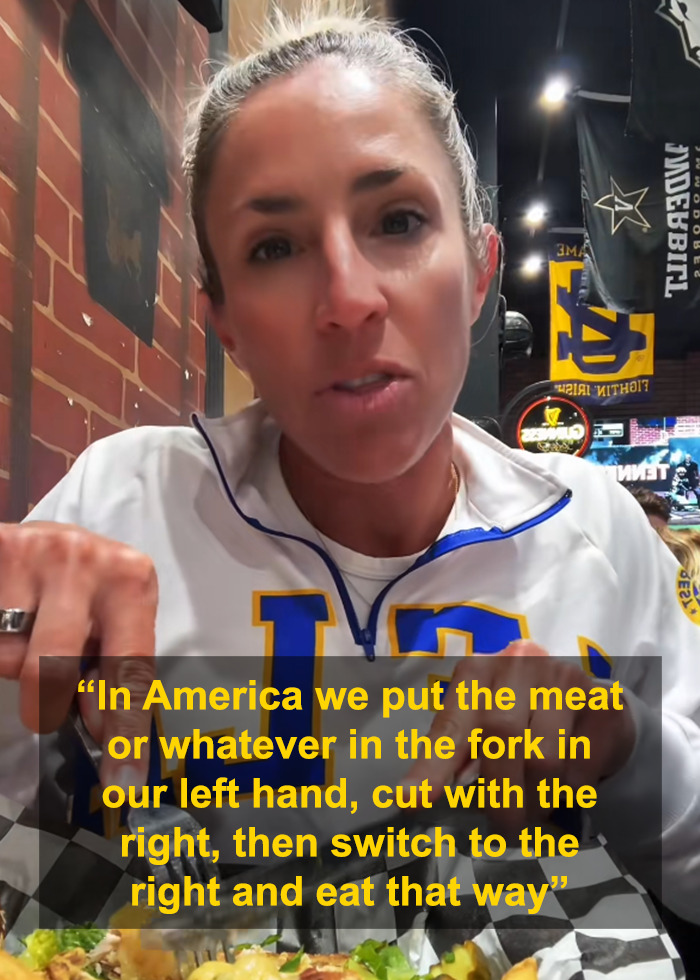 Woman explaining American eating habits with cutlery at a restaurant, highlighting primitive way of eating with fork and knife.