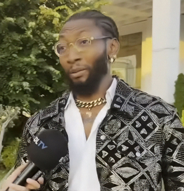 Man with glasses and patterned jacket being interviewed, related to plastic surgery ends in tragedy after party with surgeon.