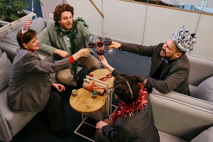 Group of friends wearing festive accessories clinking wine glasses celebrating, reflecting on driving away potential life partners.