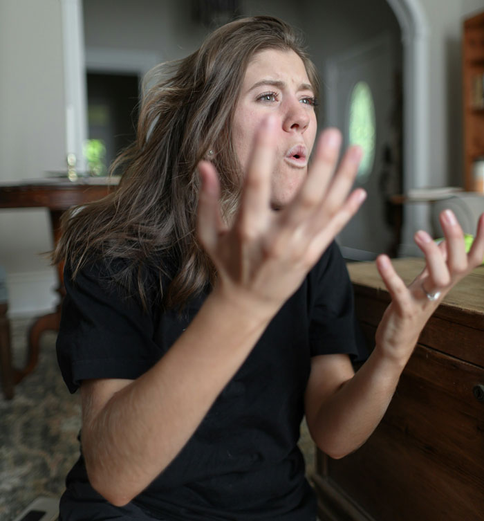 Woman expressing frustration indoors, illustrating wife threatening husband with cold shower due to his bad memory.