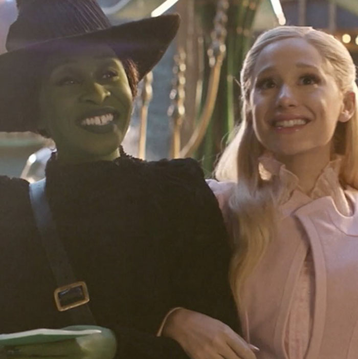 Two women smiling, one with entirely visible ribcage makeup in a ghoulish style from Wicked trailer.