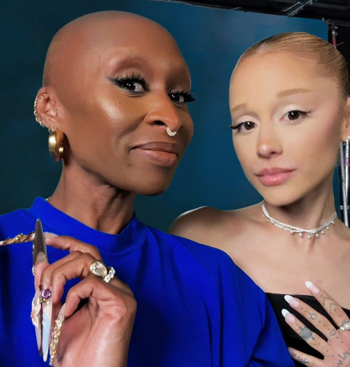 Two women posing closely together with dramatic makeup, highlighting Ariana Grande's entirely visible ribcage look.