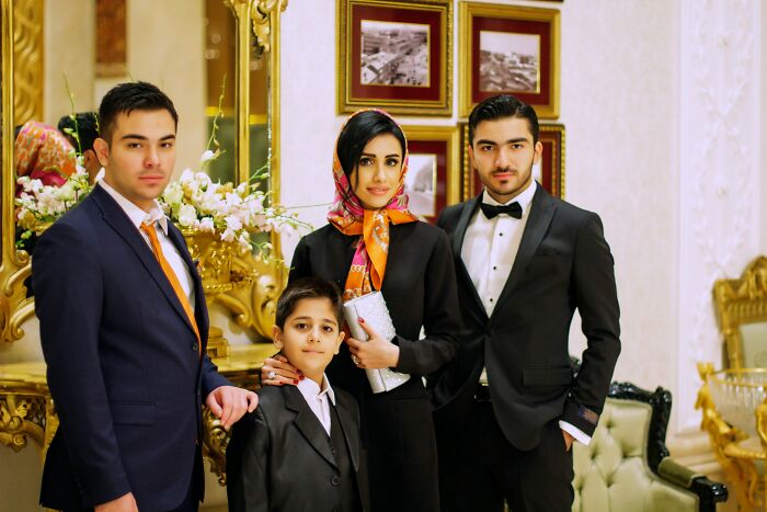 A well-dressed family poses in a luxurious room.