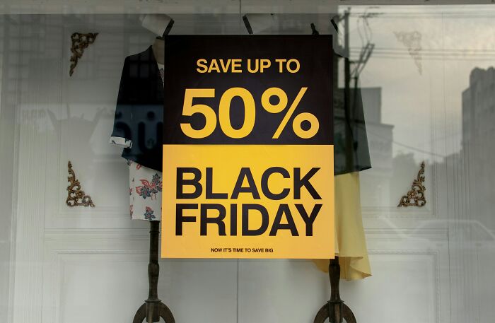Black Friday sale sign in a store window offering savings up to 50 percent during a major shopping event.