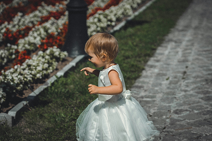 Young child wearing a white dress at an outdoor family wedding, capturing moments related to bride’s legacy. Young child wearing a white dress at an outdoor family wedding, capturing moments related to bride’s legacy.