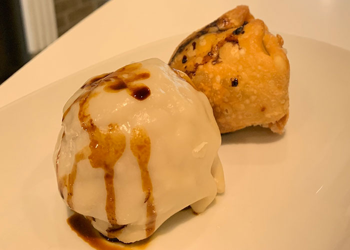 Two fried dumplings on a white plate, illustrating strange things autopsy doctors have discovered on the job.