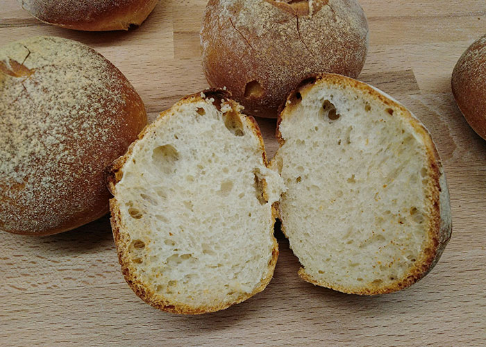 Close-up of freshly baked bread rolls on a wooden surface, illustrating strange things autopsy doctors have discovered.
