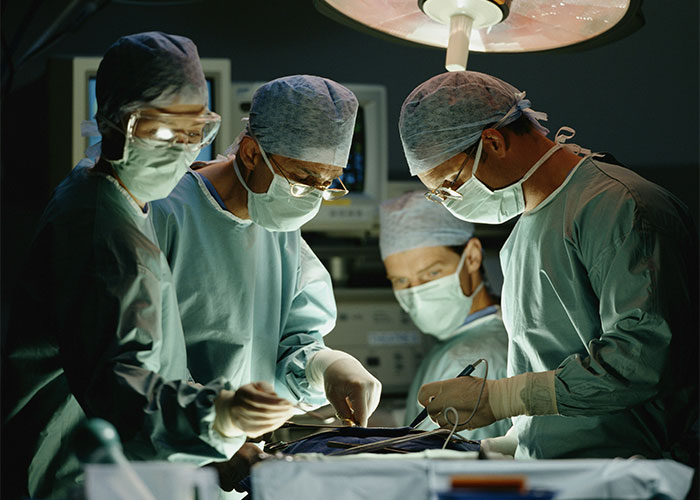 Medical team in surgical scrubs performing an autopsy, highlighting strange things autopsy doctors have discovered on the job.