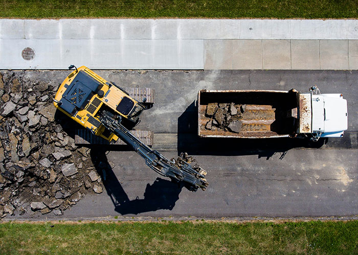 Aerial view of excavation machinery loading debris into a truck, illustrating strange things autopsy doctors have discovered.