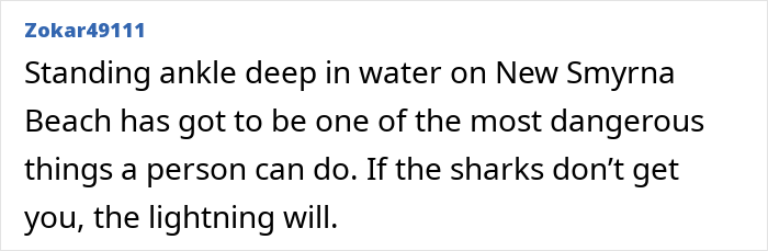 Newlywed standing ankle deep in water on New Smyrna Beach facing danger from sharks and lightning.