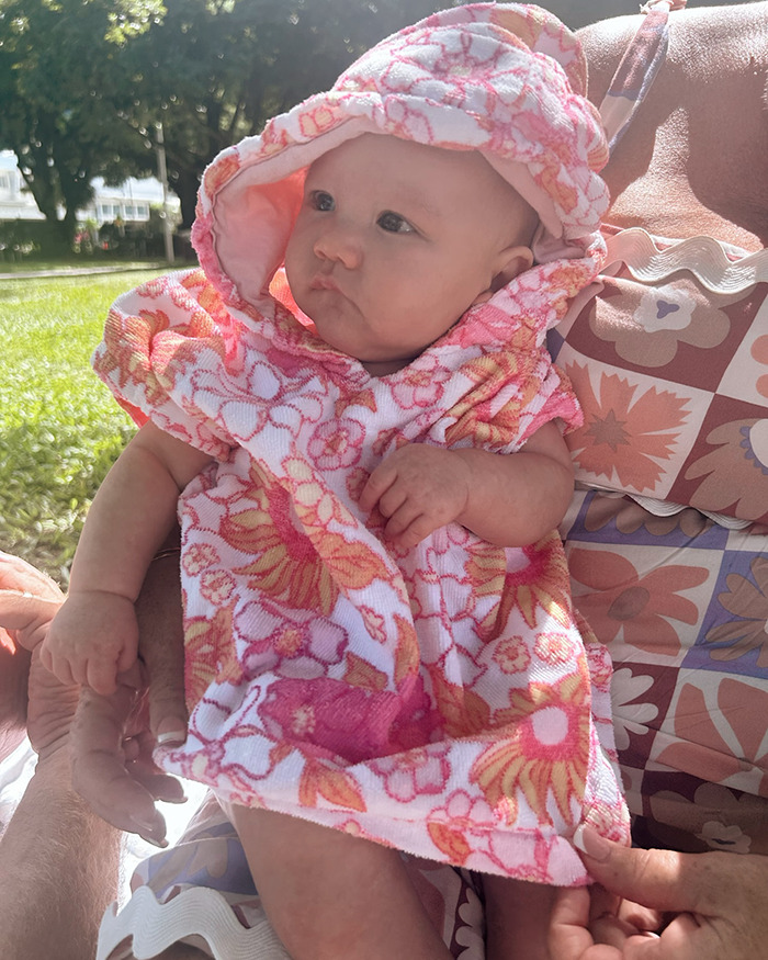 5-month-old baby wearing floral hooded towel outdoors, representing incident of fire extinguisher prank gone wrong by teens.
