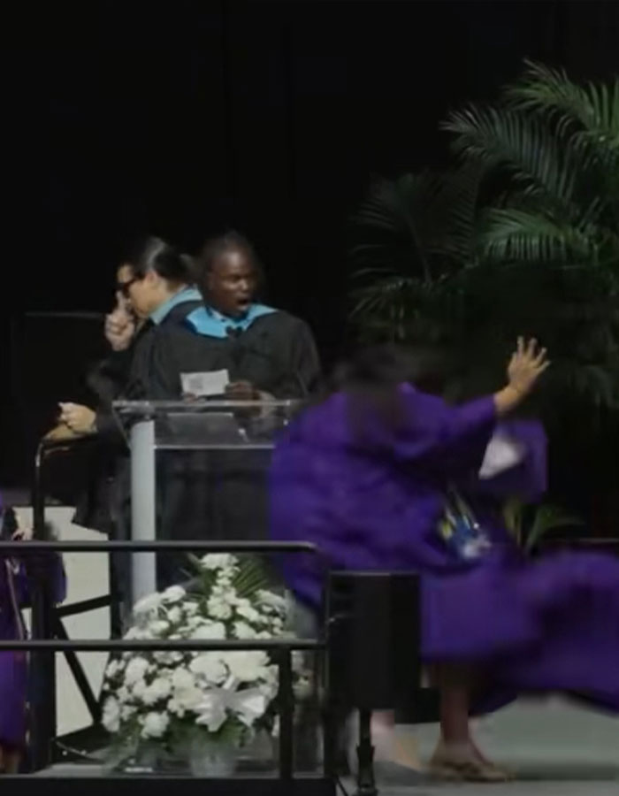 Florida high school grad in purple gown crashes into classmate during viral stage mishap at graduation ceremony.