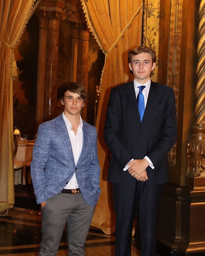 Two young men dressed formally standing in an elegant room, related to Barron Trump and illegal alien ICE claims. Two young men dressed formally standing in an elegant room, related to Barron Trump and illegal alien ICE claims.