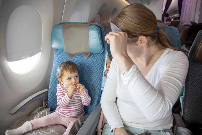 Passenger reacting to crying baby on airplane during mid-flight meltdown sparking parenting versus passenger debate