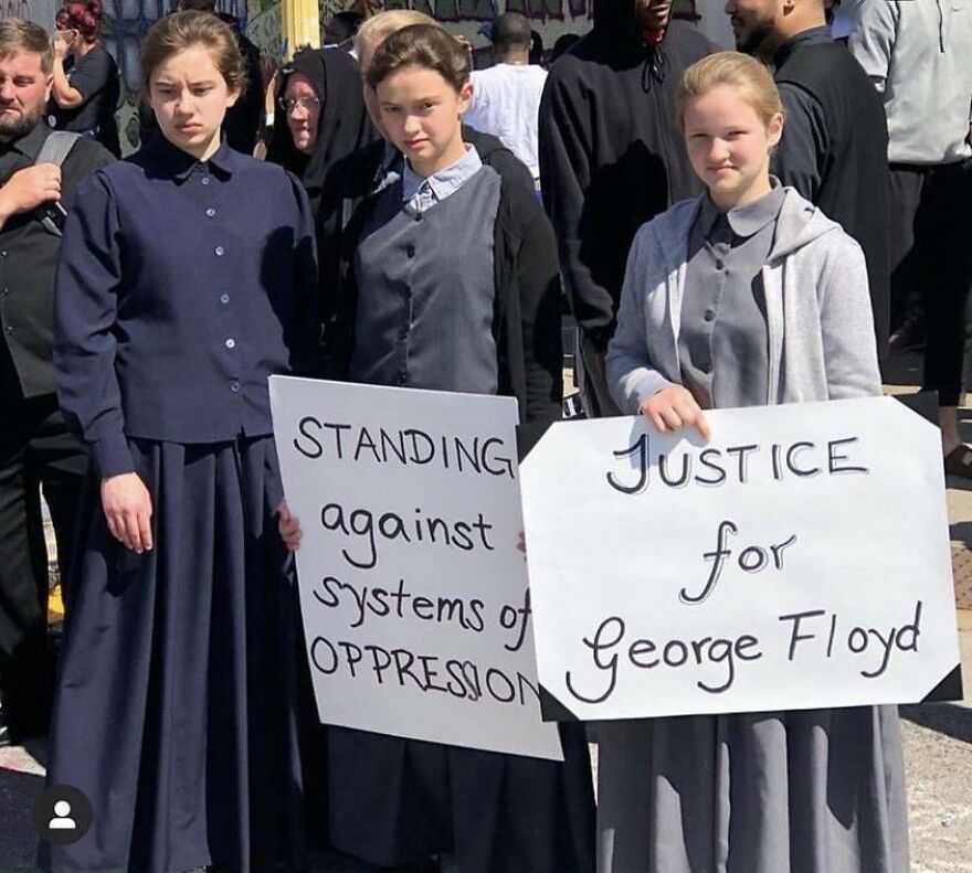 Three young people holding signs with perfect handwriting that read messages against oppression and for justice.
