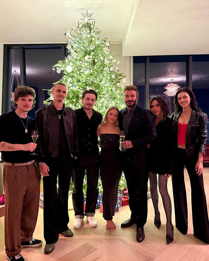 Brooklyn Beckham with family near decorated Christmas tree during holiday gathering amid alleged no contact feud.