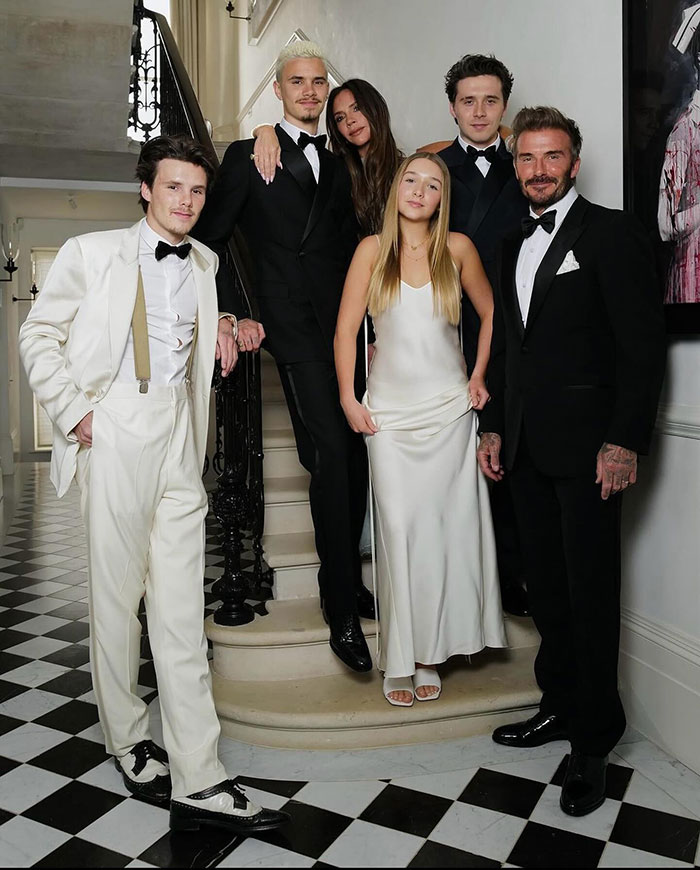 Brooklyn Beckham and family dressed formally, posing on staircase in a stylish home amid reported no contact feud.