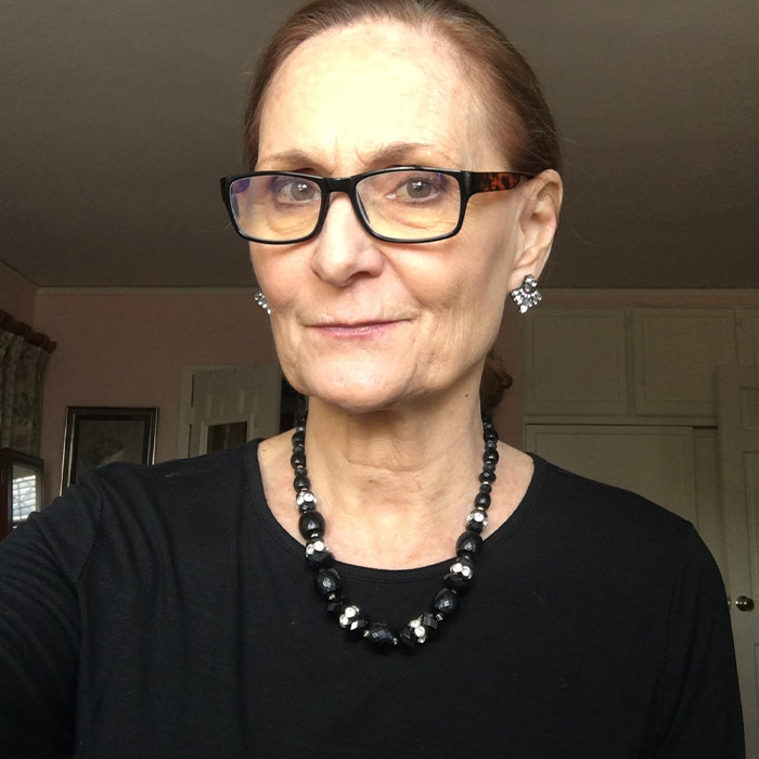 Beloved 90s star and Rain Man co-star wearing glasses and black outfit, photographed indoors with a neutral expression.