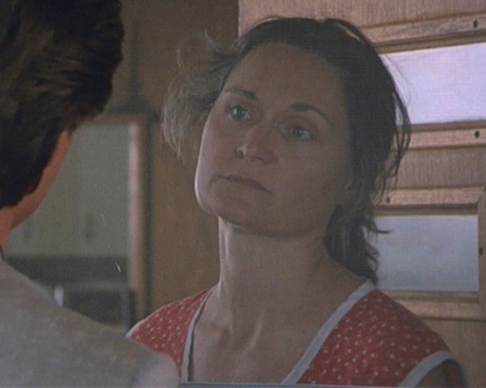 Beloved 90s star and Rain Man co-star in a vintage film scene looking serious and contemplative indoors.