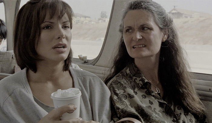Two women sitting inside a vehicle, one holding a cup, highlighting a beloved &rsquo;90s star and Rain Man co-star.