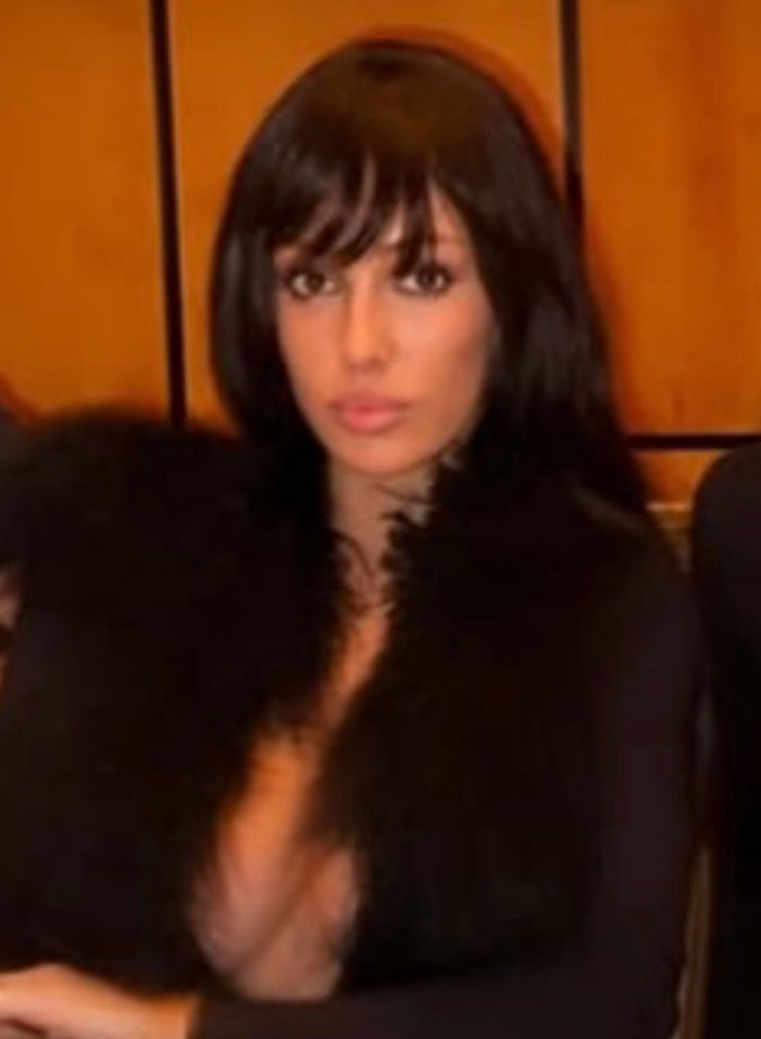 Woman with dark hair wearing a black fur garment, related to Kanye West allegedly paying Bianca Censori to wear a racy look.
