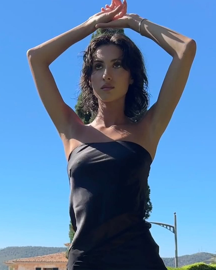 Woman posing outdoors in a black strapless dress with arms raised, reflecting themes from Kanye&rsquo;s next target and grooming fears.