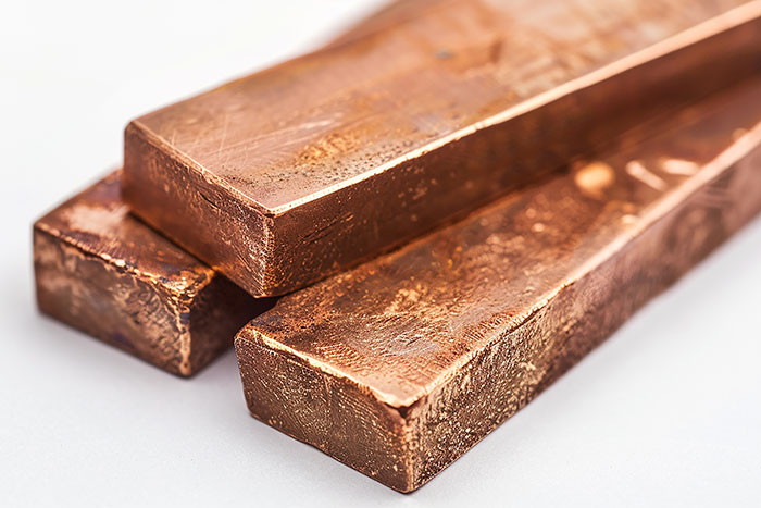 Three rough copper bars stacked on a white surface, illustrating a concept related to the biggest scandal in human history.