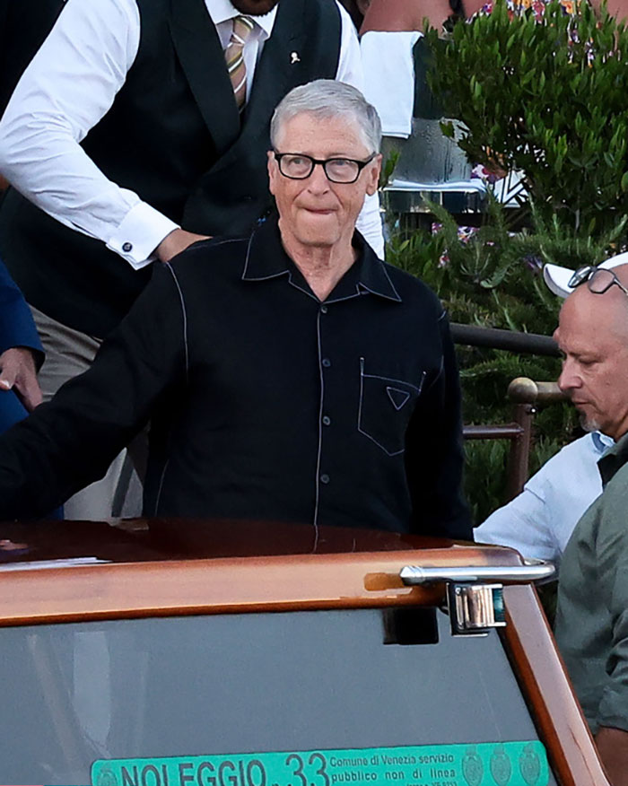 Man in black pajama-style shirt at an outdoor event, capturing the racy revealing looks from Jeff Bezos and Lauren S&aacute;nchez's afterparty.