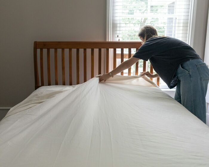 Millennial woman making a bed in natural light, illustrating industries impacted by millennial lifestyle changes.