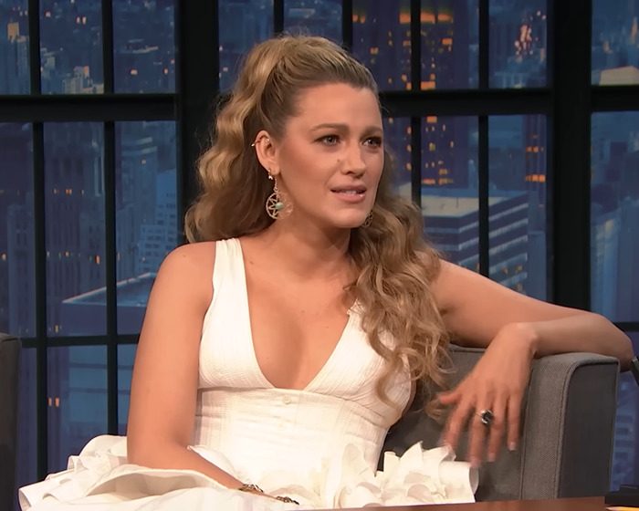 Blake Lively wearing a white dress during a TV interview, discussing lawsuit news related to Justin Baldoni.