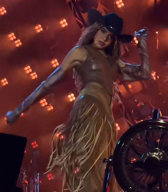 Beyonc&eacute; performing on stage in a cowboy outfit during a show with cigarette stunt sparking reactions online