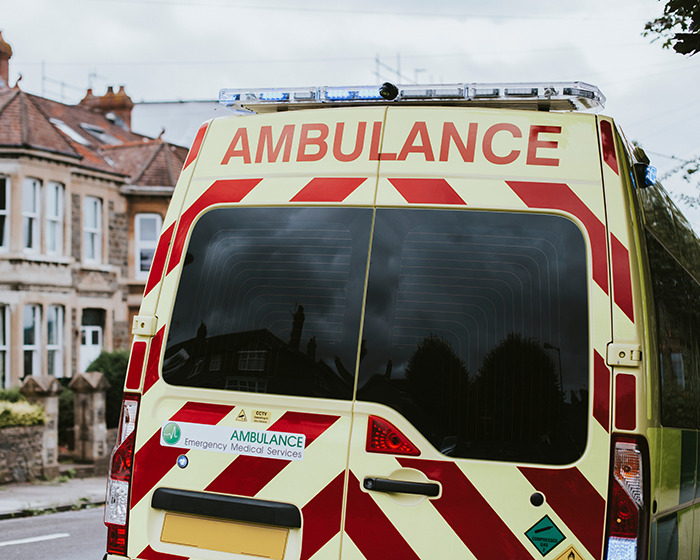 Rear view of an ambulance parked on a residential street responding to an emergency involving a viral scarf challenge incident.