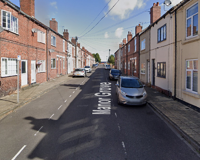 Residential street with parked cars and brick houses on both sides, related to boy 12 passes away viral scarf challenge news.