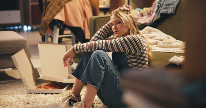 Sad young woman sitting on the floor alone with pizza boxes, reflecting on boyfriend bouquet and wedding bride feelings. Sad young woman sitting on the floor alone with pizza boxes, reflecting on boyfriend bouquet and wedding bride feelings.