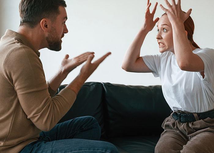 Woman and man arguing indoors, woman refusing to leave after planning a party, tension over privacy demands.