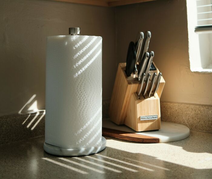Kitchen countertop with paper towel holder and knife block, highlighting poor people habits in everyday household items.