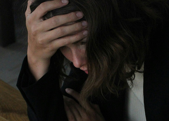 Woman with long brown hair holding her head in frustration, illustrating moments when people broke guy or girl code.