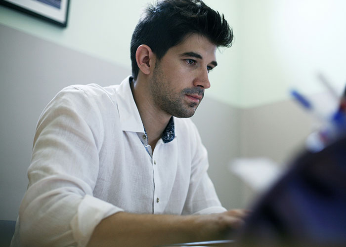 Man focused on laptop screen indoors, illustrating moments when people broke guy or girl code for better choices.