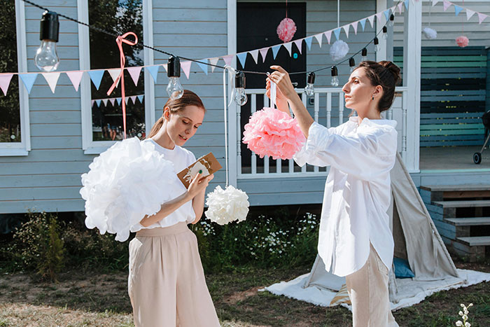 Two women preparing decorations outdoors for a bride&rsquo;s dream bachelorette with strict rules before the party begins.