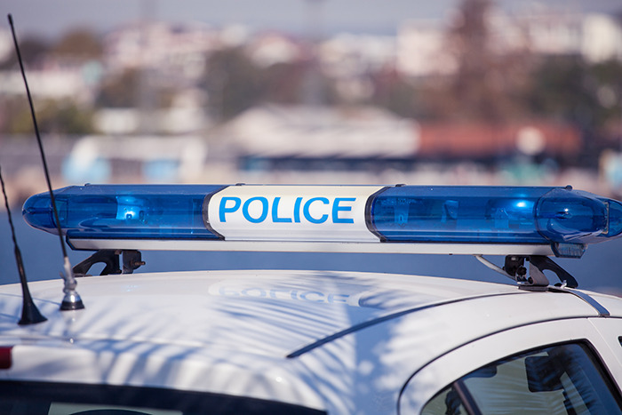 Close-up of a police car roof with blue emergency lights, symbolizing the arrest of a man with a disturbing criminal record.