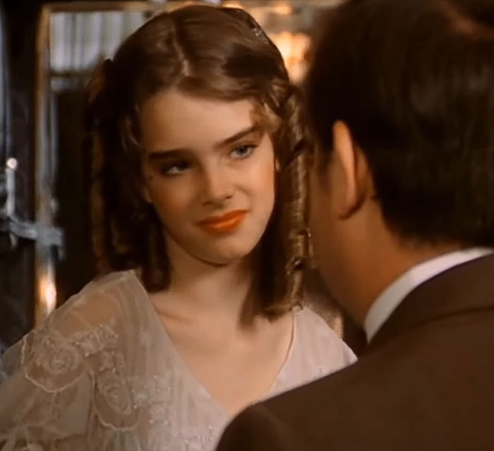 Brooke Shields in a vintage film scene, engaging in conversation, related to Meghan Markle podcast interview controversy.