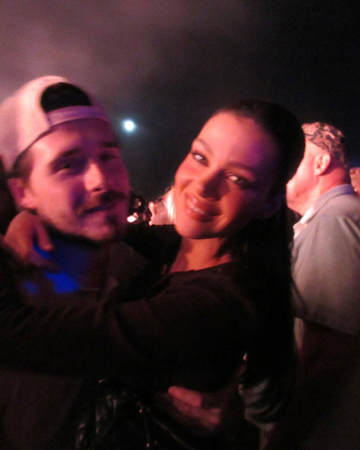 Brooklyn Beckham with a woman at night, amid fiery feud and alleged no contact with parents David and Victoria Beckham.