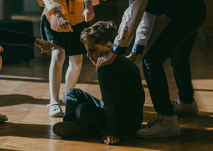 5th grade boys bullied by girls in school, showing a tense moment of confrontation and peer aggression indoors. 5th grade boys bullied by girls in school, showing a tense moment of confrontation and peer aggression indoors.