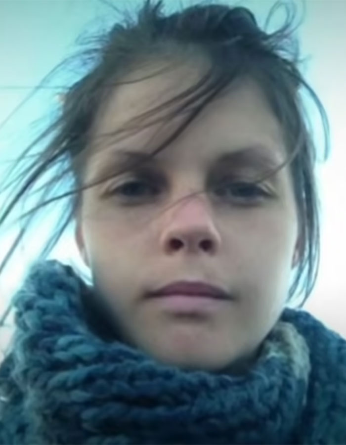 Young Australian woman with windswept hair wearing a thick blue scarf, highlighting risks of excessive caffeine consumption.